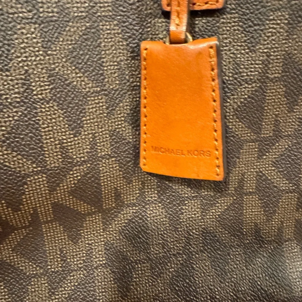 Michael Kors Emblemed satchel style purse. Strap has some gold chain and leather